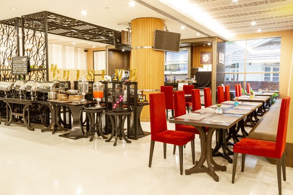 A restaurant with a long counter, red chairs, and a buffet area. - FuramaXclusive Sukhumvit (Bangkok)