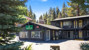 A two-story building with a sign for "Heavenly Inn" and an American flag. - Heavenly Inn (South Lake Tahoe)