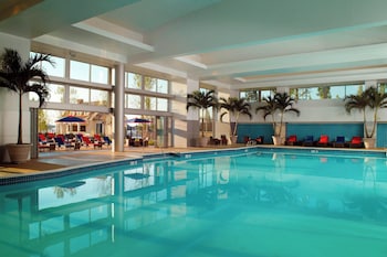 Indoor pool, open 8:00 AM to 10:00 PM, pool umbrellas, sun loungers at Gaylord National Resort & Convention Center