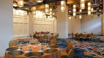 A conference room with round tables, chairs, and water bottles.