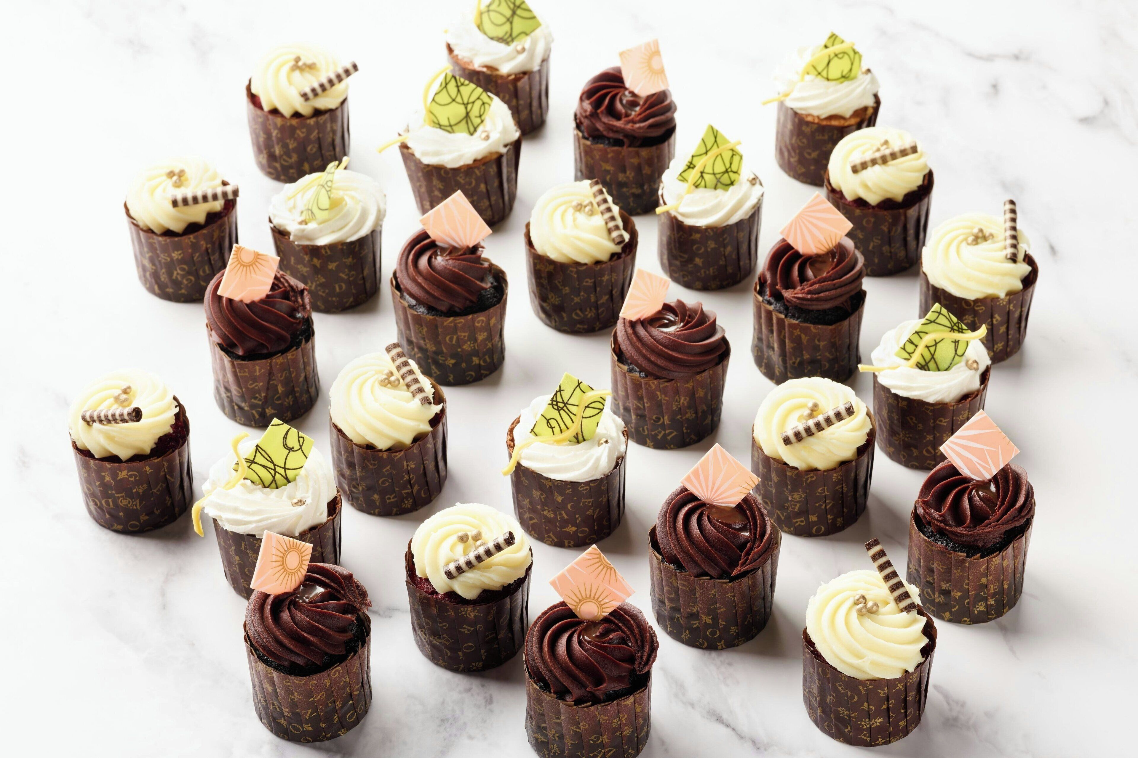 Une collection de petits gâteaux décorés, disposés sur une surface en marbre.