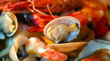 Primer plano de un plato de mariscos con almejas y camarones.