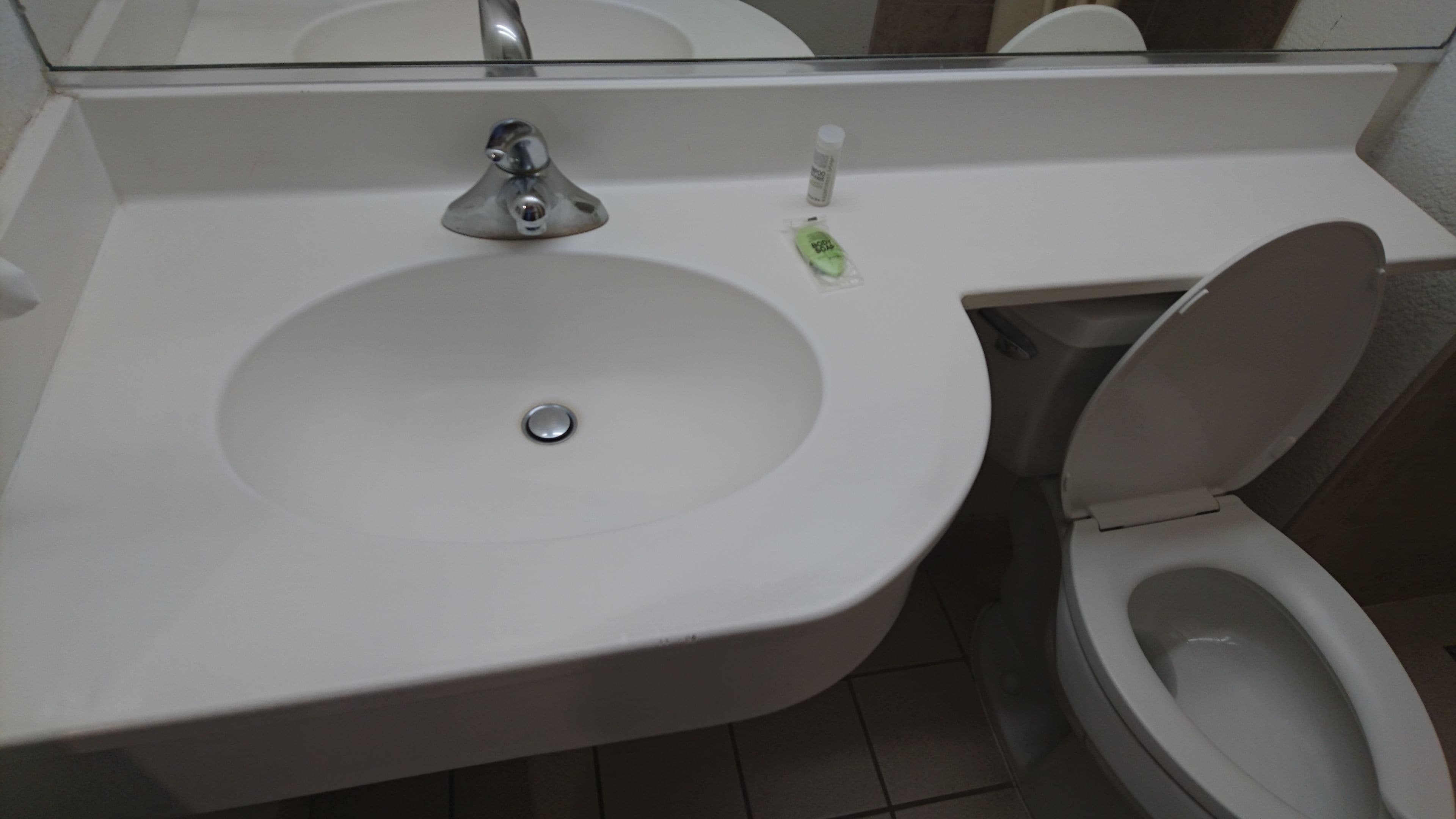 A bathroom with a white sink, a mirror above it, and a toilet.