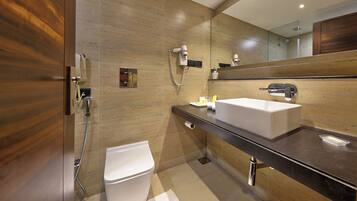A modern bathroom with a wooden vanity, a white sink, and a large mirror.