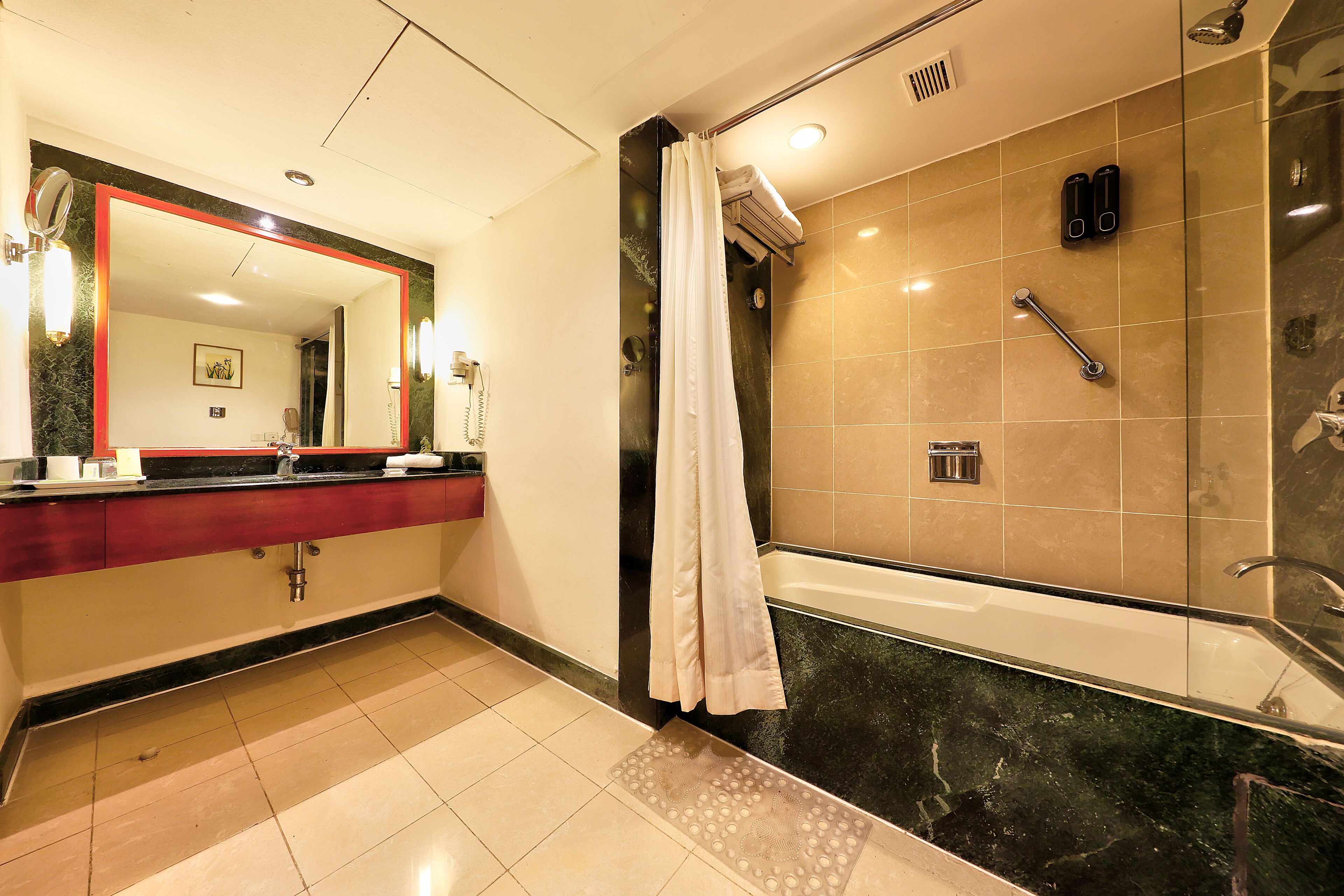 A bathroom with a large mirror, a sink, a shower, and a bathtub.