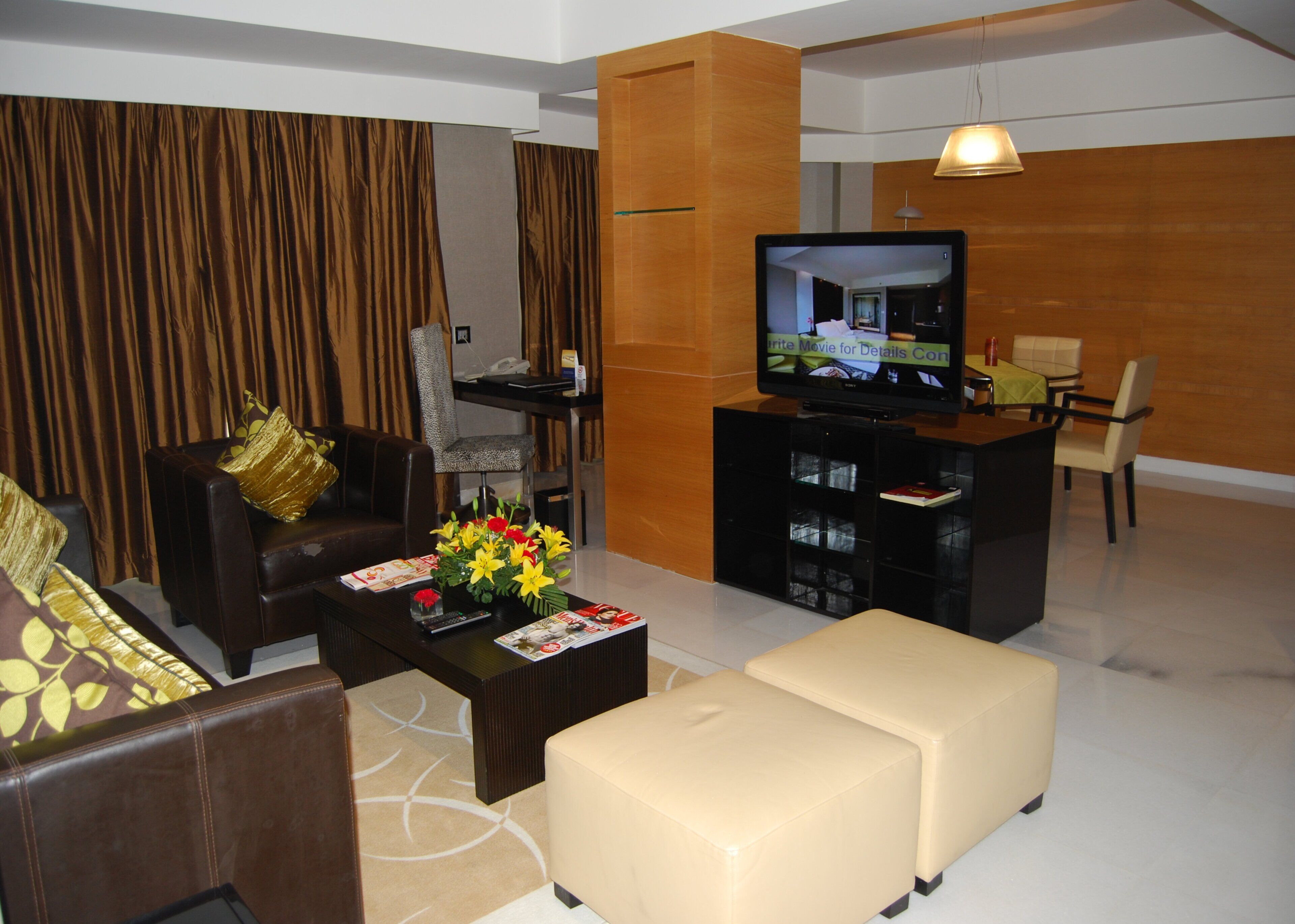 A modern living room with a sofa, ottoman, coffee table, and a television.