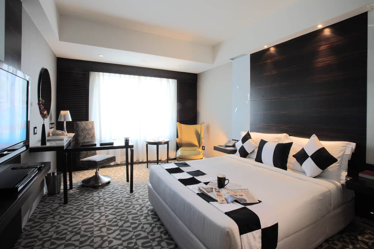 Una habitación de hotel moderna con una cama grande, un escritorio y una silla.