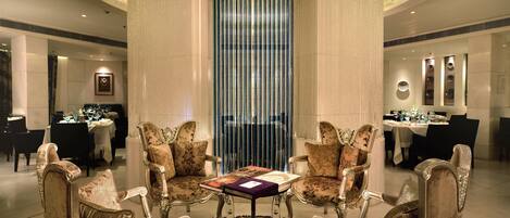 A luxurious dining area with ornate chairs, a central table, and a decorative column.