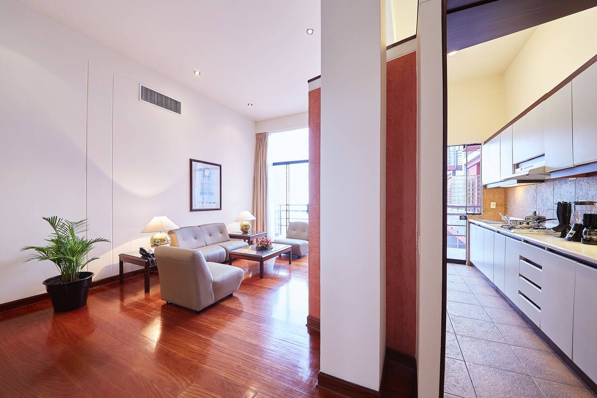Una sala de estar moderna con sofá, mesa de centro y una planta en maceta.