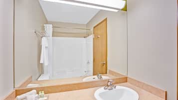 Un baño con un espejo grande, un lavabo y una zona de ducha.