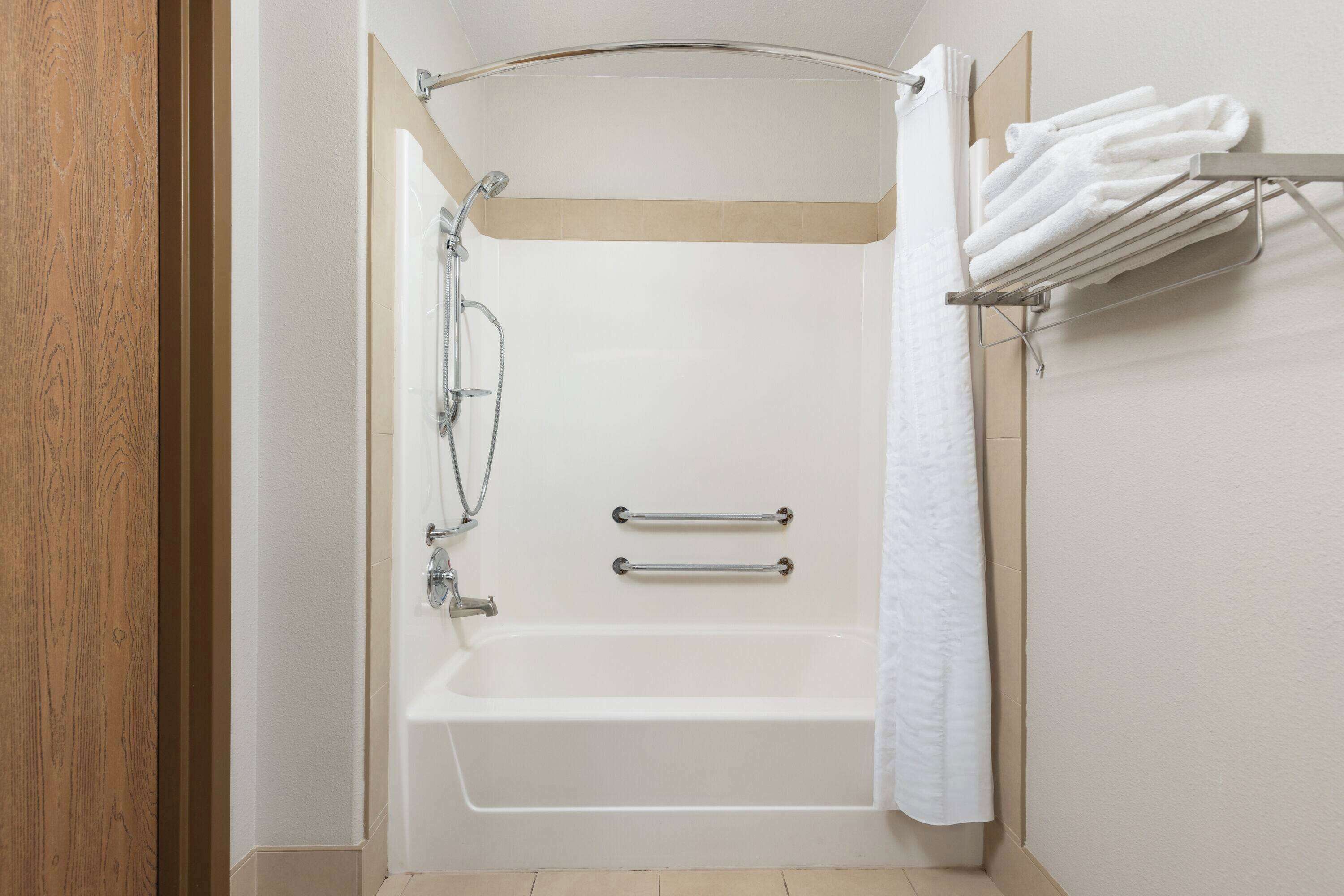 Un baño moderno con bañera, ducha y toallero.