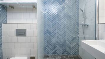 A bathroom with a shower, toilet, and sink.