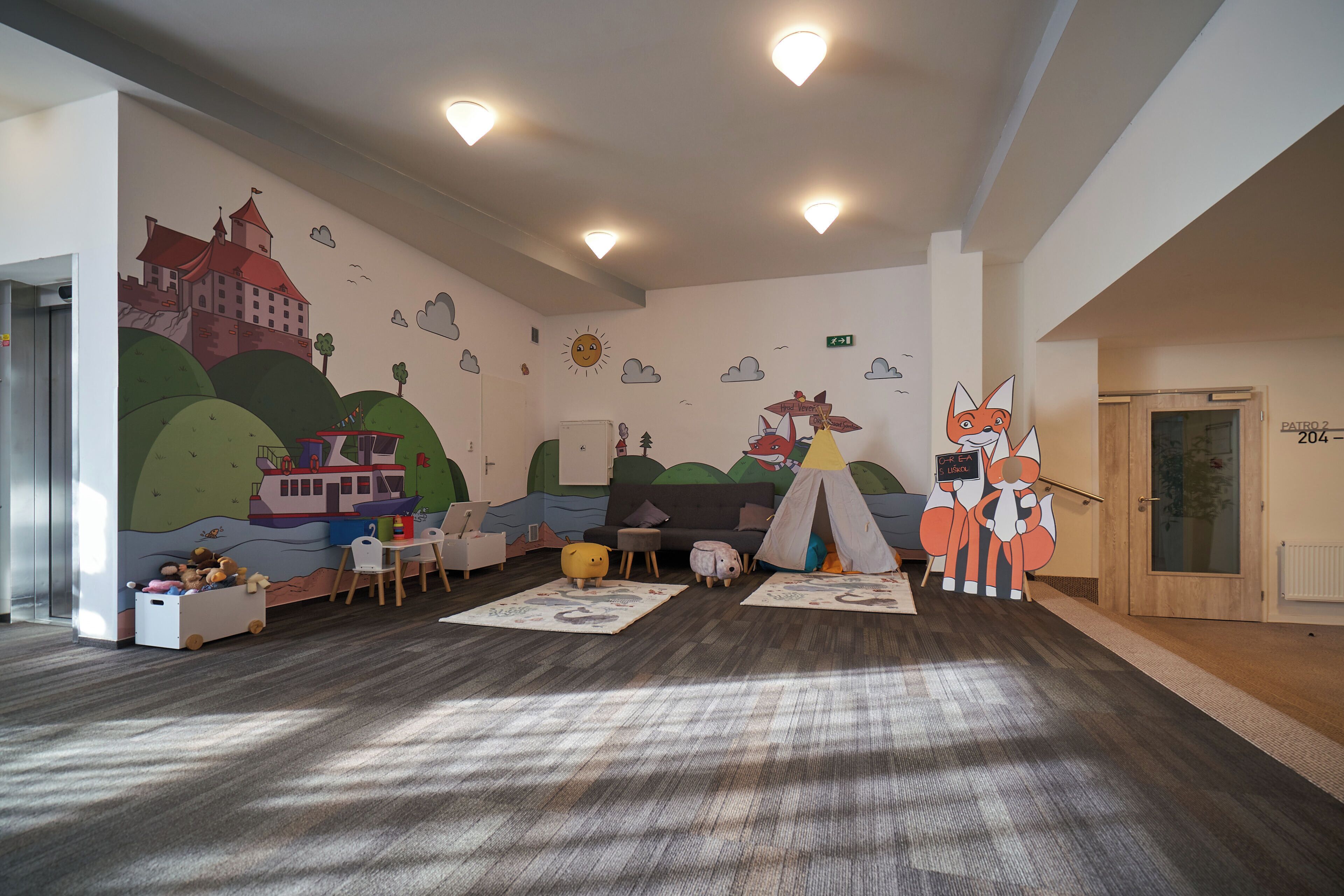 Ein Spielzimmer für Kinder mit Wandmalerei eines Schlosses, einem Zelt und einer Fuchsdekoration.