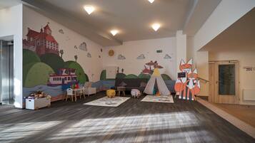 Ein Spielzimmer für Kinder mit Wandmalerei eines Schlosses, einem Zelt und einer Fuchsdekoration.