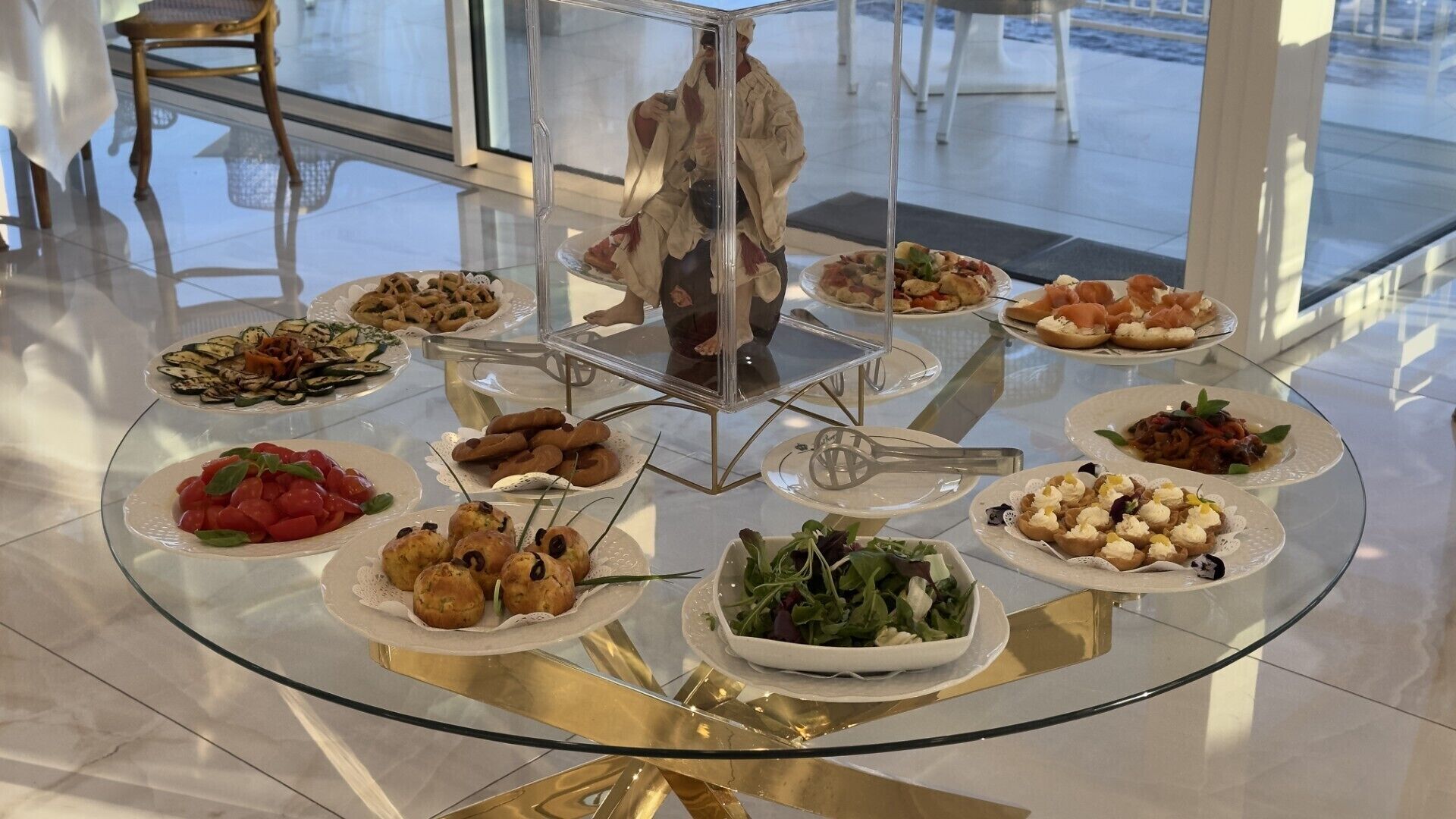 A glass-top table with various dishes arranged around it.