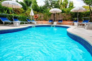 季節性室外游泳池，提供泳池遮陽傘和日光浴躺椅