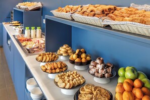 Un buffet proposant une variété de produits de boulangerie et de fruits.