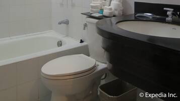 Un baño moderno con bañera, inodoro y lavabo con espejo.
