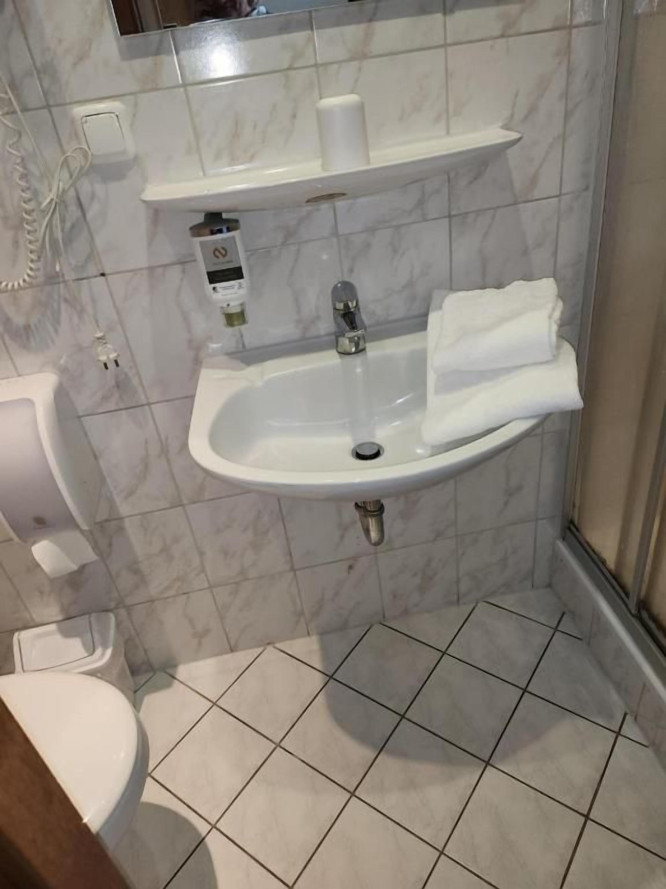 A bathroom with a toilet, sink, and shower.