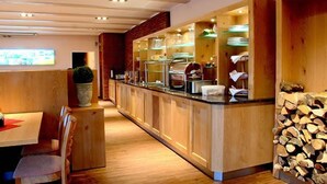 Un restaurant doté d’un long comptoir, de meubles en bois et d’un présentoir où sont exposés les différents plats proposés.