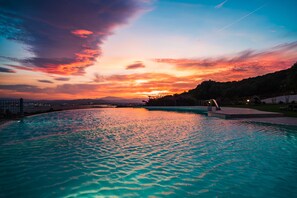 Una piscina al aire libre de temporada, sombrillas, tumbonas