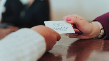 A person holding a business card with "Hotel dP" and "Colbia - Sardinia" text.
