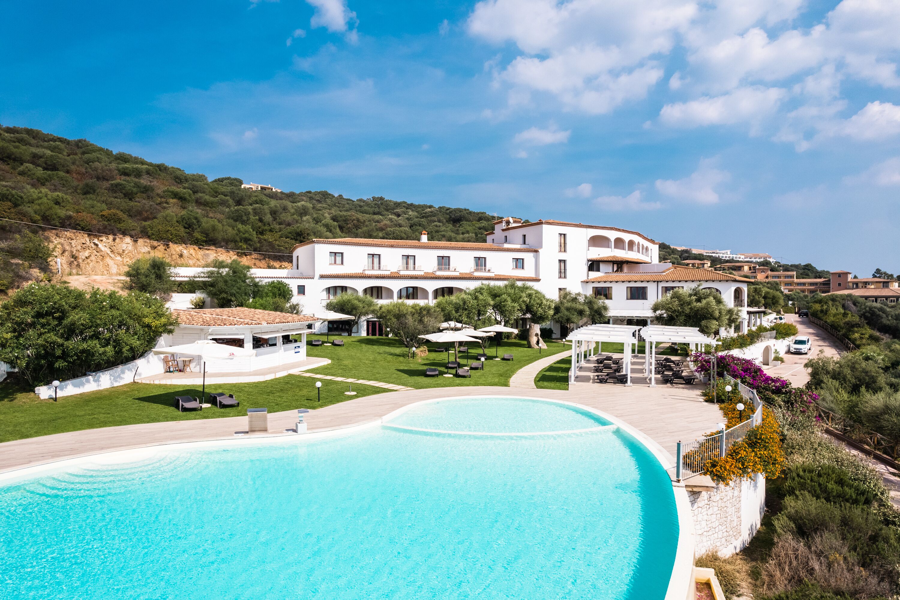 A large swimming pool with a white building in the background.