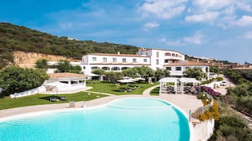 Uma piscina grande com um edifício branco ao fundo.