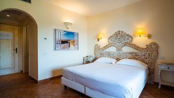 A bedroom with a large bed, two bedside tables, a decorative headboard, a wall-mounted picture, and a door with a vent.