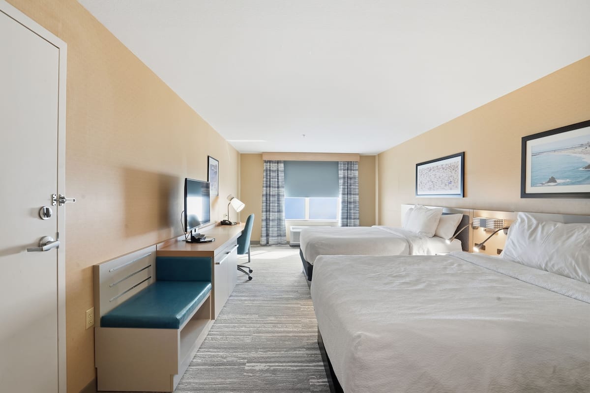 Een hotelkamer met een bed, bureau, stoel en een televisie.