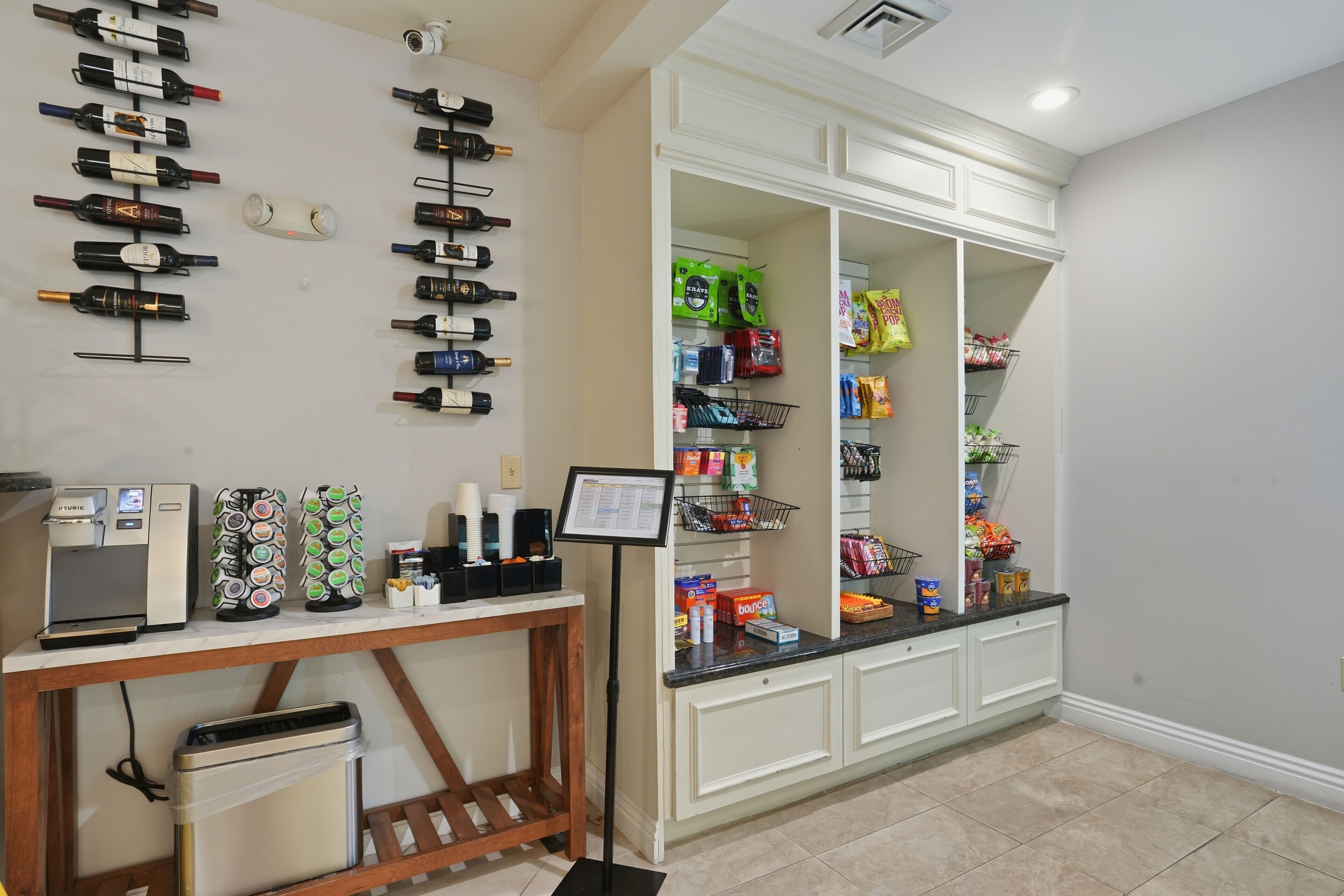 A hotel reception area with a coffee machine, a wine bottle display, and a snack bar.