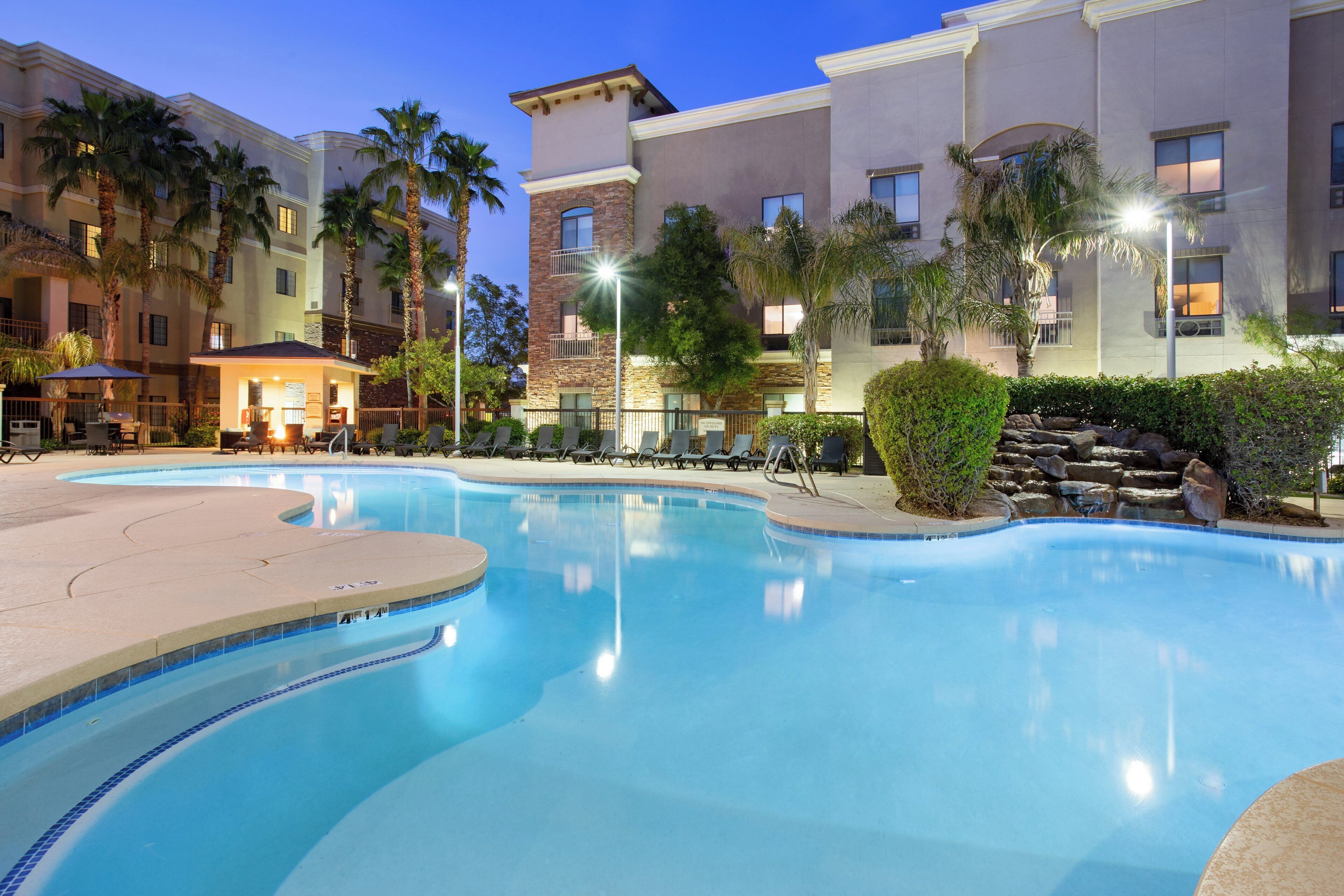 A swimming pool with lounge chairs and a sun patio area.