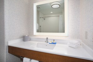 A bathroom with a white sink, a mirror, and a shower visible in the reflection. - Holiday Inn Express & Suites Phoenix - Glendale Sports Dist by IHG (Glendale)