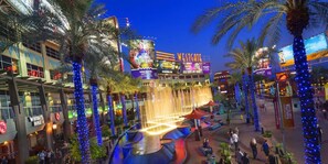A casino with a fountain, palm trees, and illuminated signs. - Holiday Inn Express & Suites Phoenix - Glendale Sports Dist by IHG (Glendale)