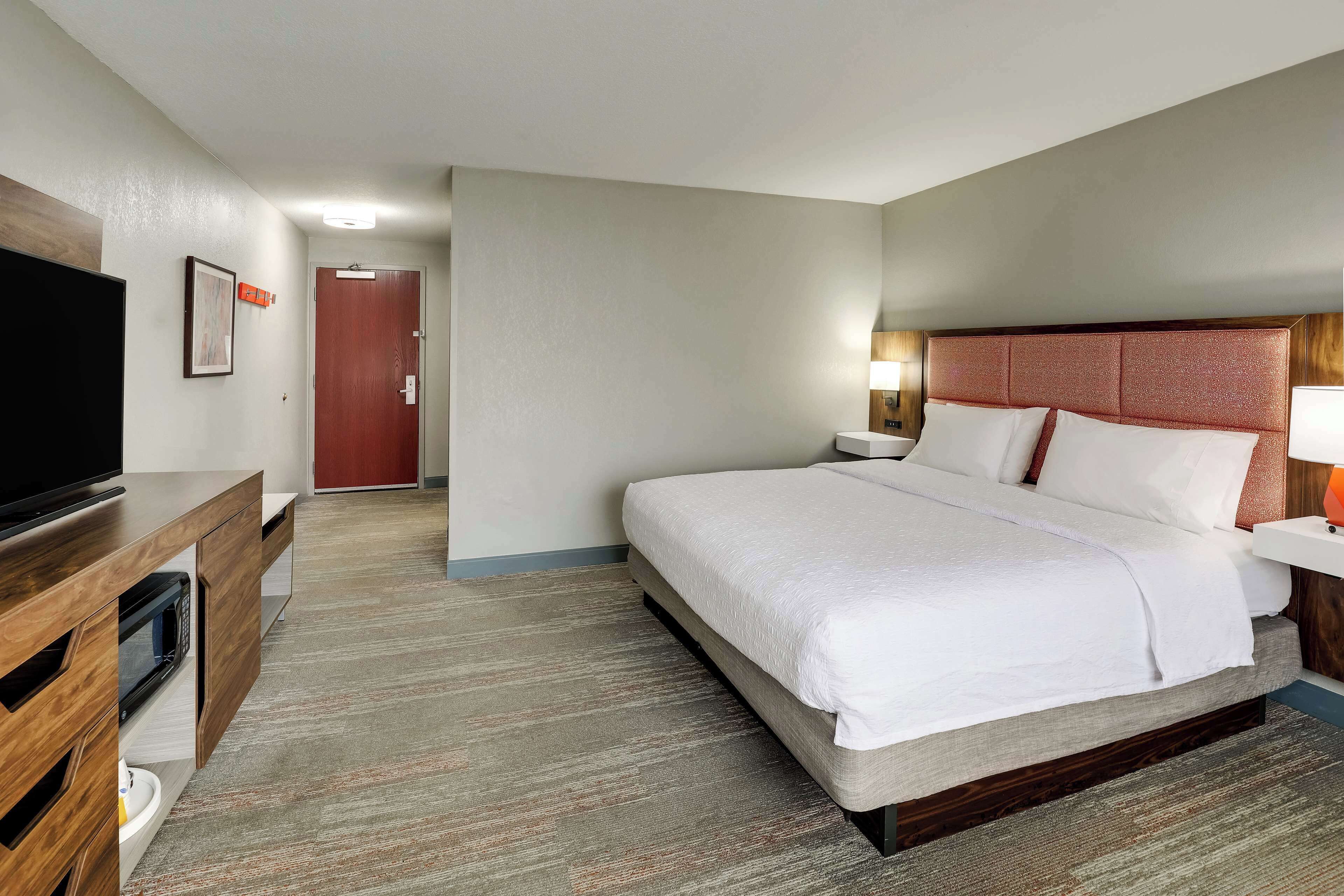Une chambre d’hôtel équipée d’un lit, d’une télévision, d’un bureau et d’un four à micro-ondes.