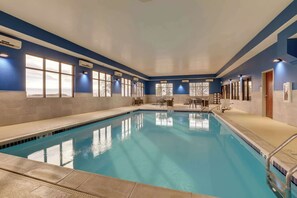 Una piscina techada, sillones reclinables de piscina