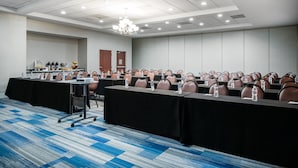 A conference room with rows of tables and chairs, a projector, and a water dispenser. - Holiday Inn Express and Suites Ontario Airport by IHG (Ontario)