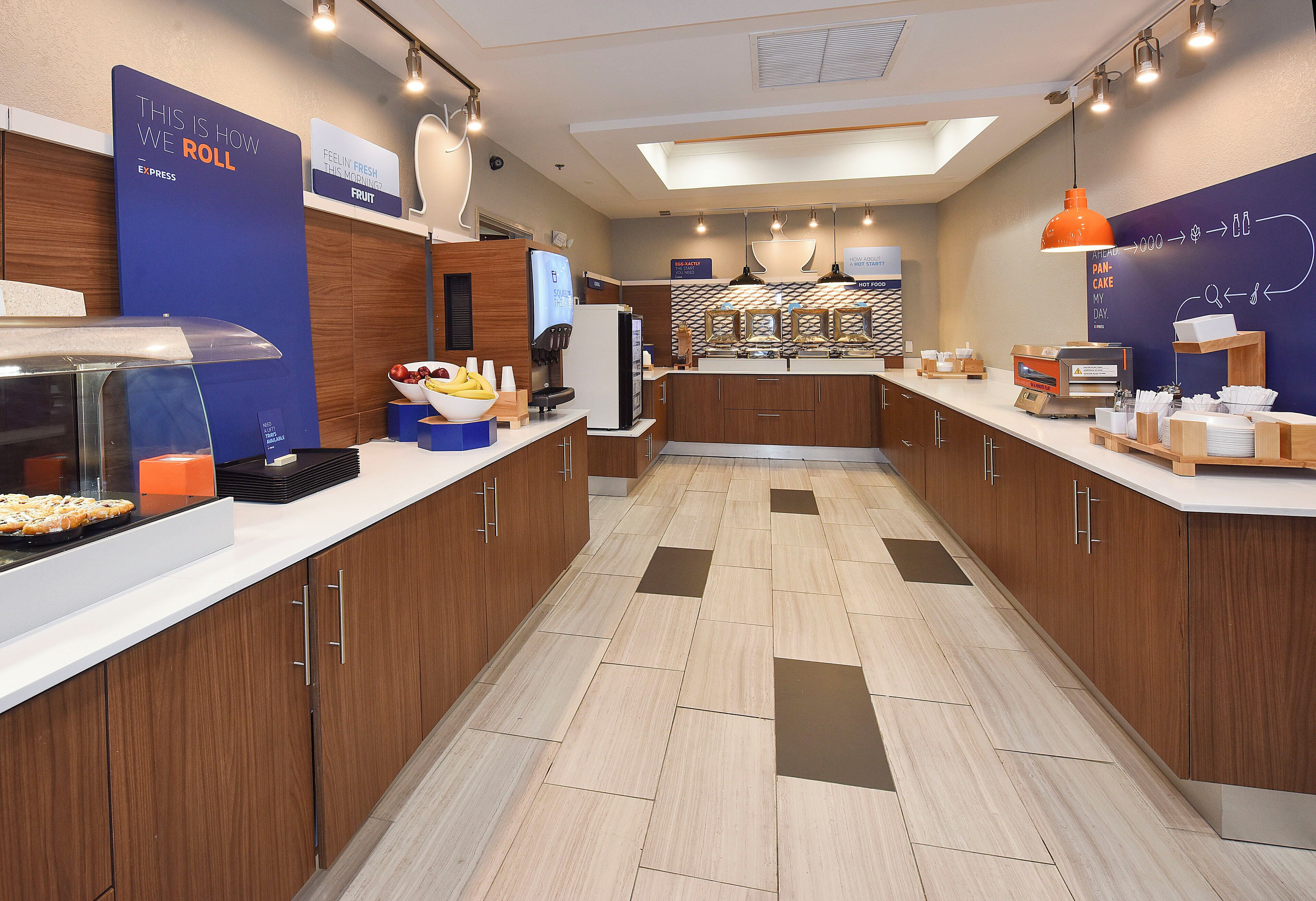 Una cocina moderna con una isla central, un dispensador de fruta y una cafetera.