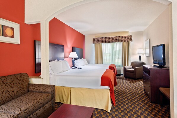 A hotel room with a large bed, a sofa, a desk with a TV, and a window with curtains. - Holiday Inn Express Hotel & Suites Malvern by IHG (Malvern)