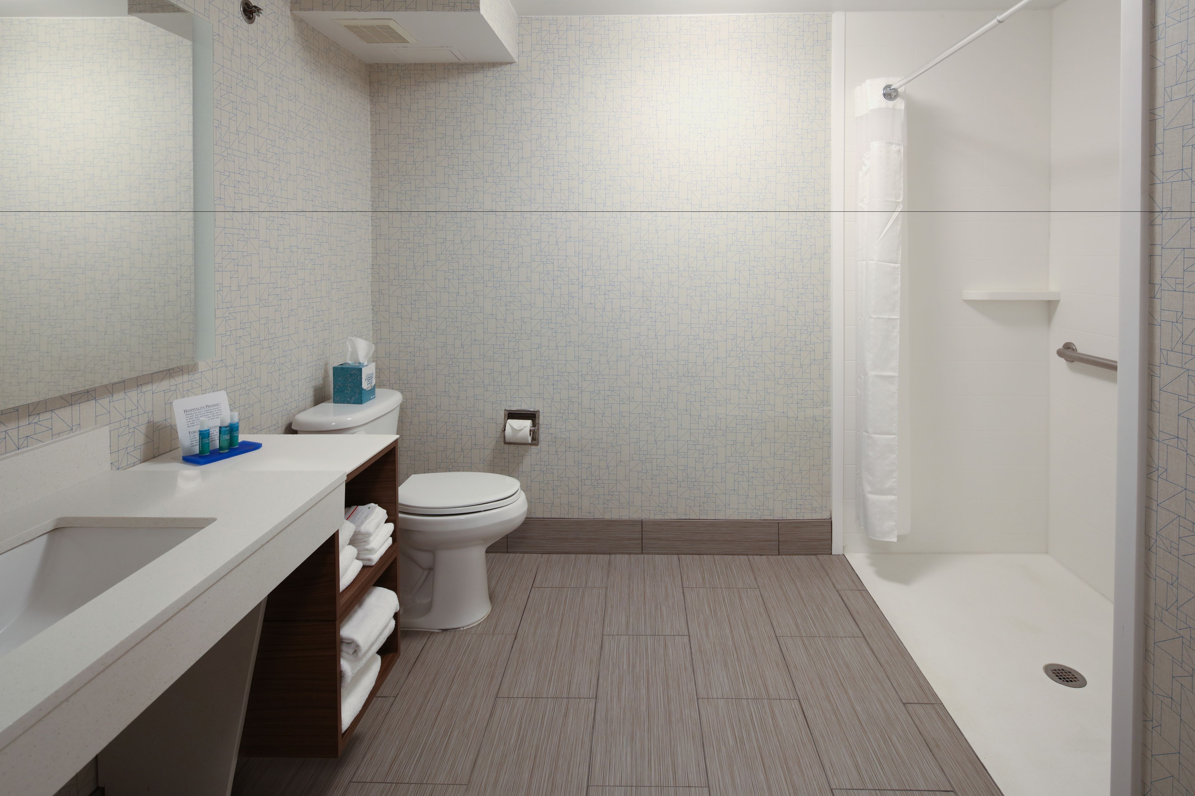 Une salle de bain moderne équipée de toilettes, d’un lavabo et d’une douche.