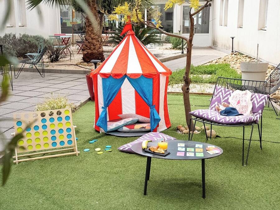 A tent, a table with food, and chairs in an outdoor area.