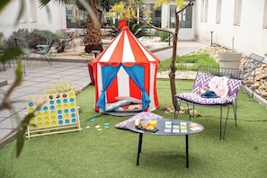 A tent, a table with food, and chairs in an outdoor area.