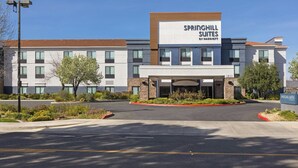 A hotel with a modern design, featuring a prominent signage for 'SPRINGHILL SUITES BY MARRIOTT' and a clear driveway leading to the entrance.