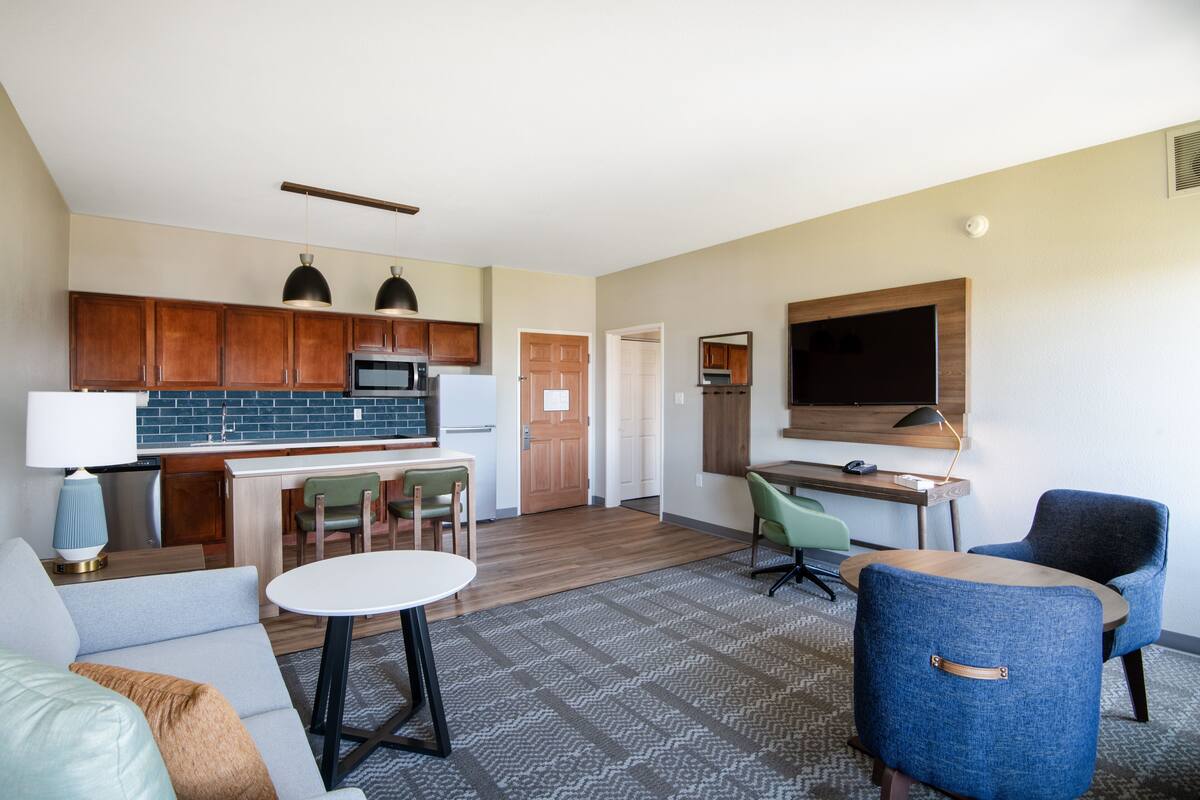 A modern apartment with a kitchen, dining area, and living room.