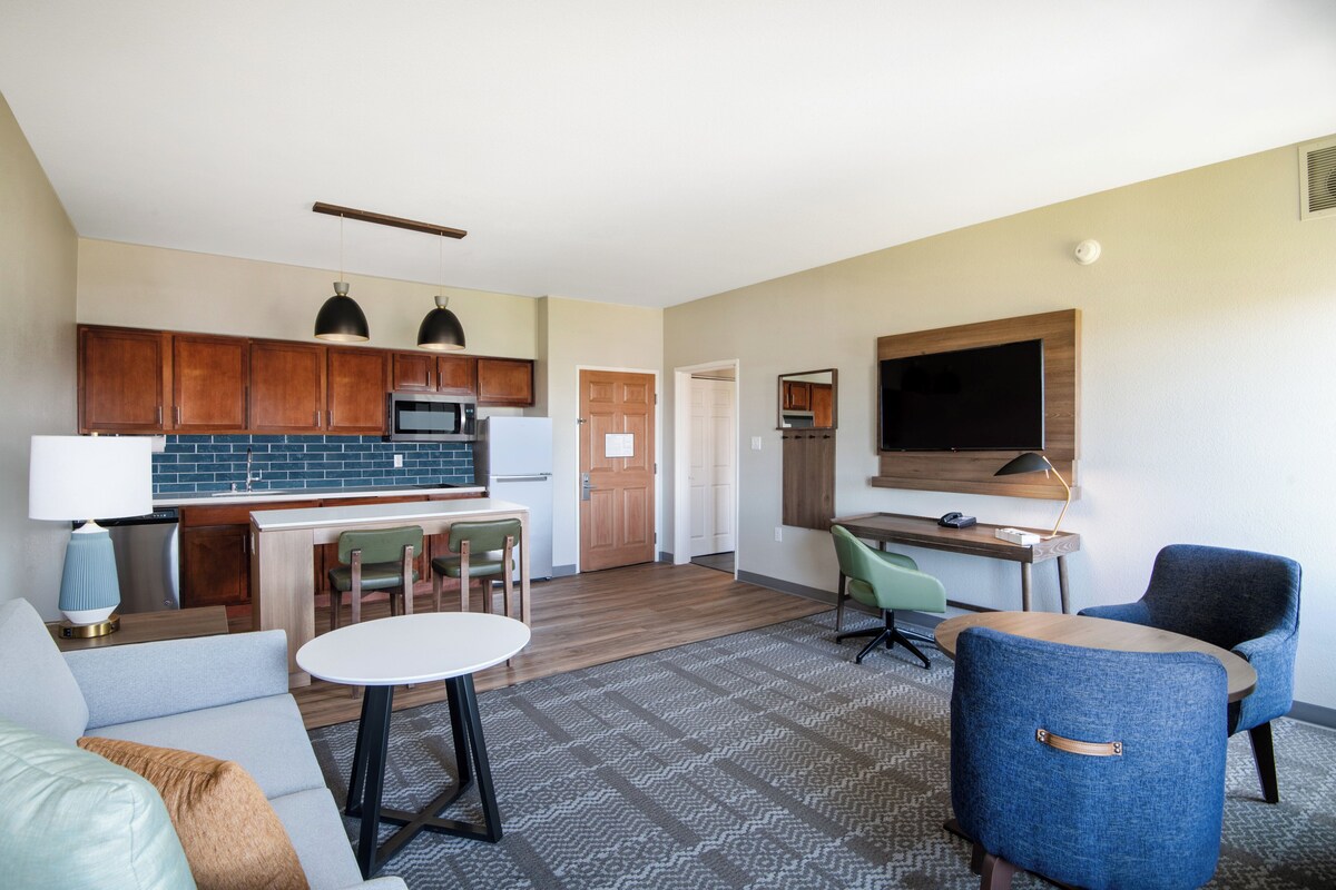 A modern apartment with a kitchen, dining area, and living room.