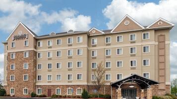 A Staybridge Suites hotel with a brick facade, multiple windows, and a central entrance.