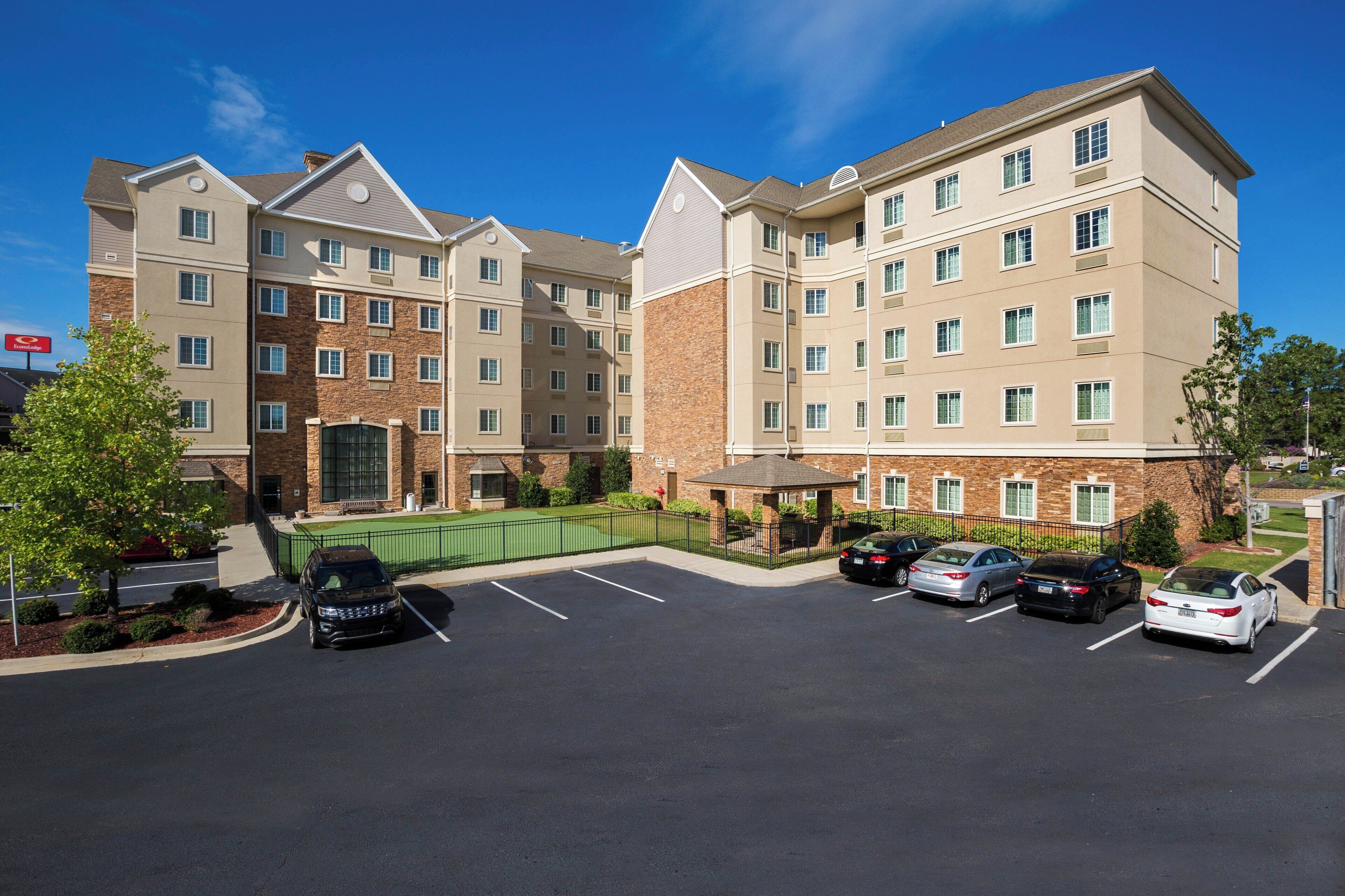 A multi-story hotel with a parking lot in front.