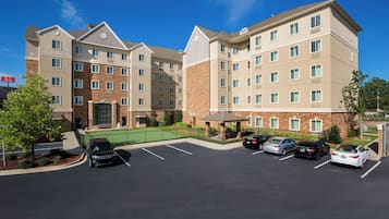 A multi-story hotel with a parking lot in front.
