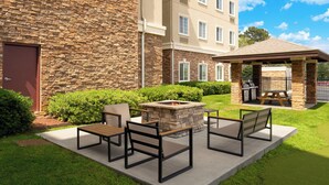 A courtyard with outdoor seating, a fire pit, and a covered barbecue area. - Staybridge Suites Augusta by IHG (Augusta)