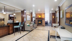 A hotel lobby with a reception desk, seating area, fireplace, and tiled flooring. - Staybridge Suites Augusta by IHG (Augusta)